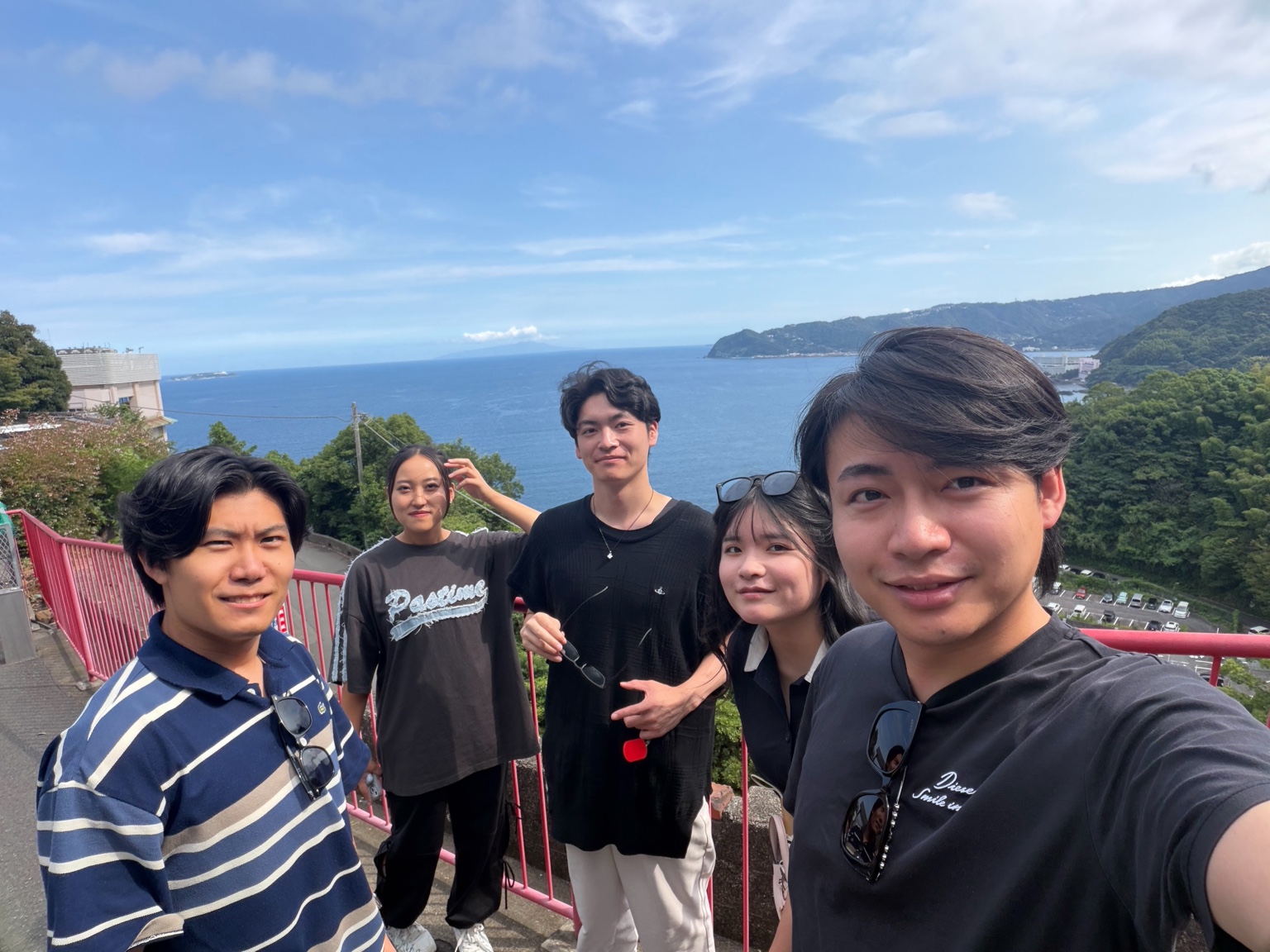 海を背景に集まる社内旅行のメンバー